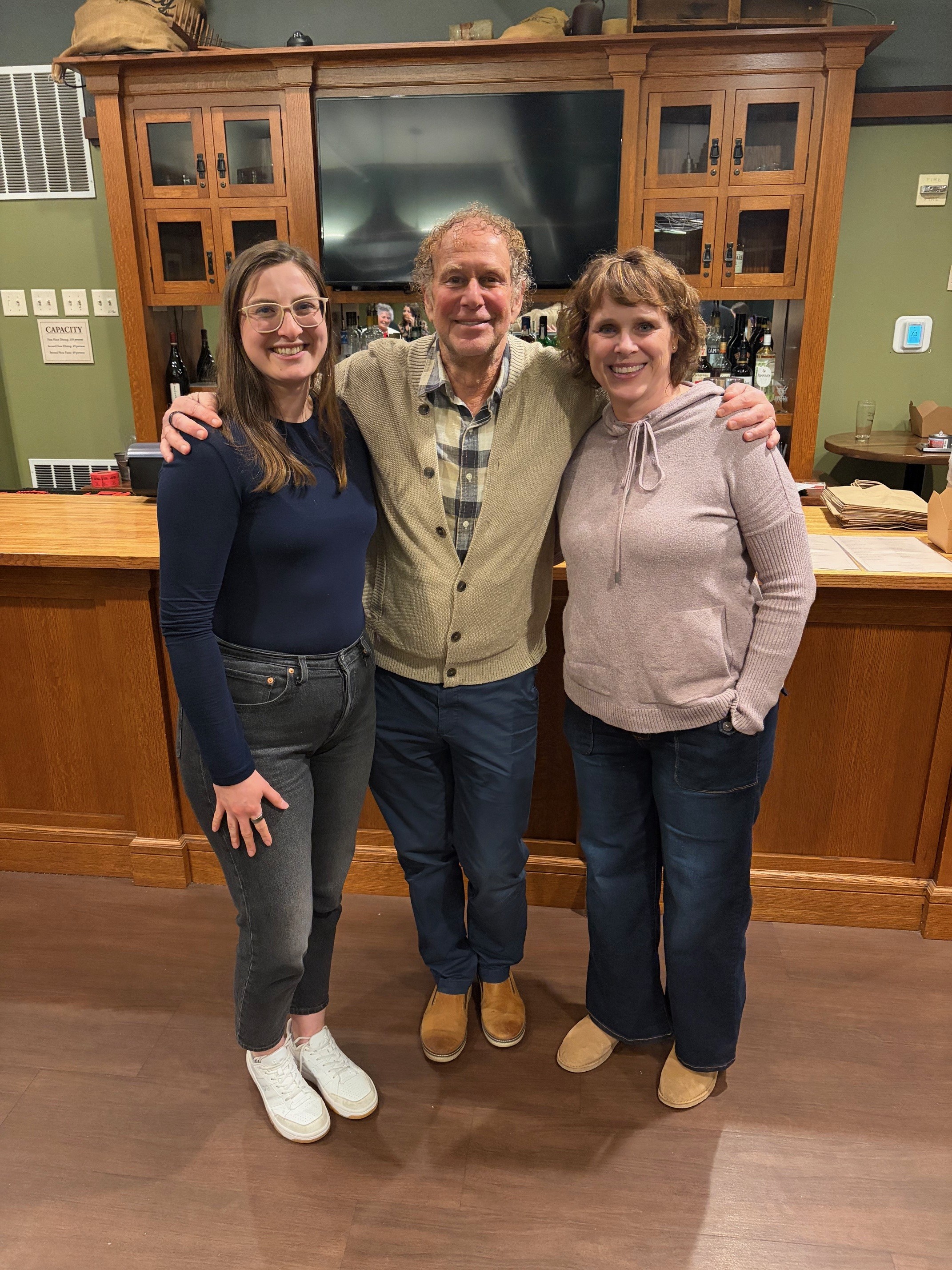 A group of three people standing next to each other