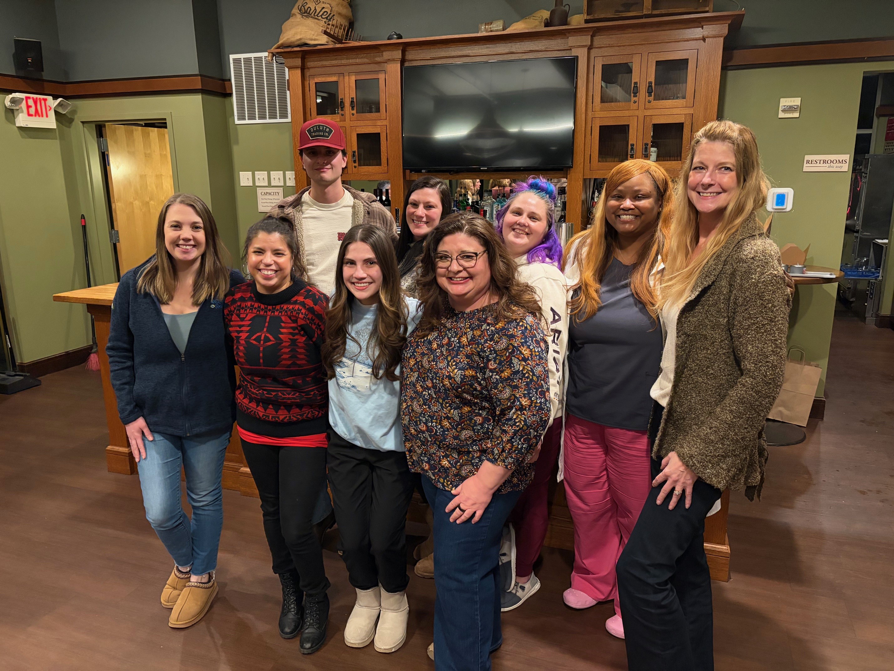 A group of three people standing next to each other