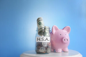 Jar with money, labeled HSA and a pink piggybank