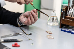 person holding glasses and using a screwdriver on them