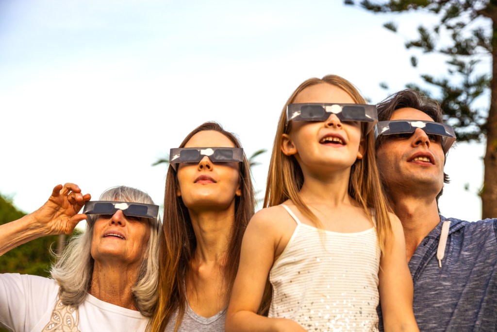 A family using protective eyewear to view a solar eclipse. 