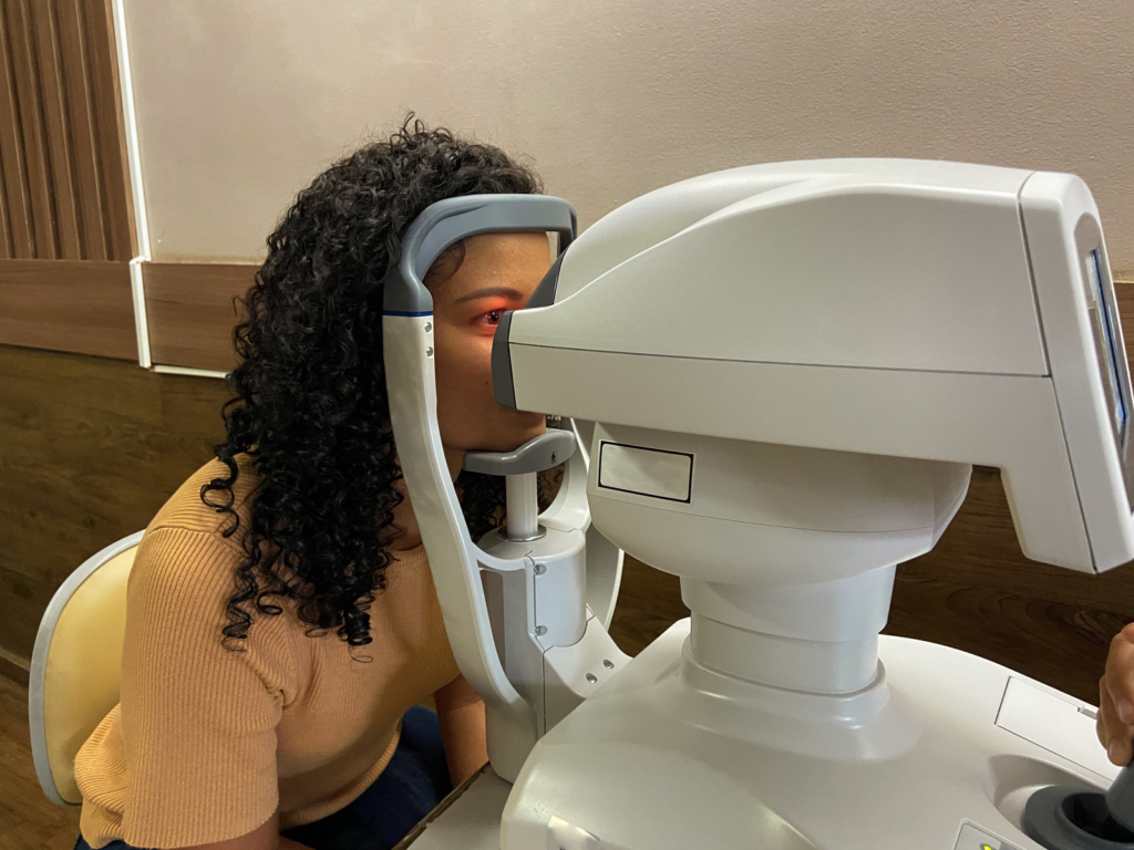 Young woman with her head resting on an eye examination machine